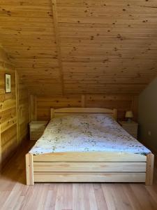 a bedroom with a bed in a wooden ceiling at Mazurskidom Zaścianek in Świętajno