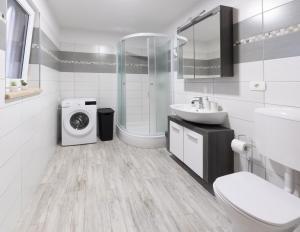 uma casa de banho branca com uma máquina de lavar roupa e um lavatório em Apartments Gea em Lucija