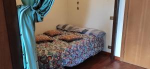 una camera da letto con un letto con un piumone di Il Nido - Delizioso alloggio presso il centro con vista spettacolare e giardino a Sauze d'Oulx