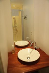 a bathroom with two white sinks on a wooden counter at B&B Le Fond de la Cour in Honfleur