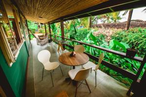 Habitación con balcón con mesa y sillas. en Pousada Verdes Mares, en Fernando de Noronha