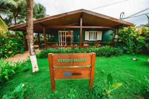 a sign in the grass in front of a house at Pousada Verdes Mares in Fernando de Noronha