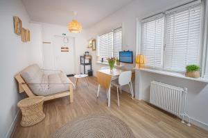 Sea Cottage Zandvoort في زاندفورت: غرفة معيشة مع مكتب وكرسي وطاولة