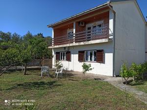 a house with a balcony and a table in the yard at Poborska Villa in Ulcinj