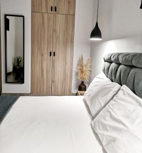een slaapkamer met een wit bed en een spiegel bij Elements Studios in Néa Péramos