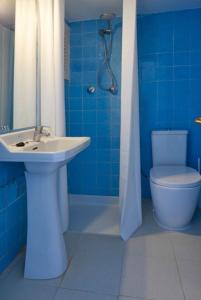 ein blaues Bad mit einem Waschbecken und einem WC in der Unterkunft Hotel Flamingo in Es Cana