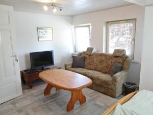 a living room with a couch and a table at Richters Deich-Oase in Brokdorf