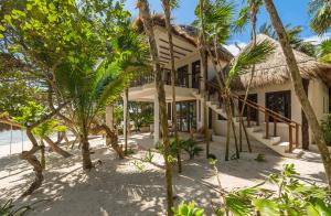 a house on the beach with palm trees at Beachfront bungalows- Soliman Bay in Tulum