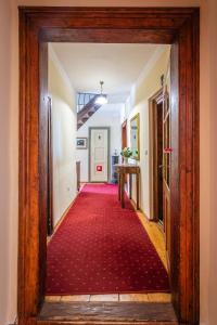 an open door to a hallway with a red carpet at Penzion Nostalgia in Banská Štiavnica