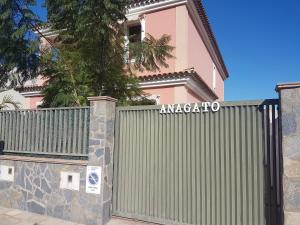 TeguesteにあるChalet Anagatoの塀付きピンクの家の門