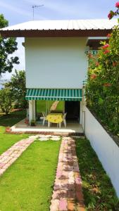 a house with a green awning and a yellow table at Appartement d'une chambre avec jardin clos et wifi a Baie Mahault in Baie-Mahault