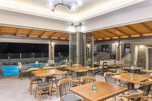 an empty restaurant with wooden tables and chairs at Oli Terra in Skala Potamias