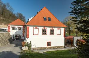 uma grande casa branca com um telhado laranja em Residence Hluboká em Hluboká nad Vltavou