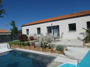 a house with a patio and a swimming pool at Villa d'Eau Douce in La Mothe-Achard