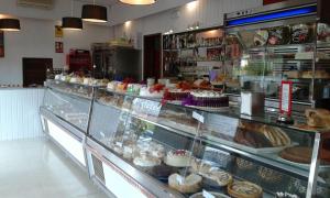 a bakery with a display case filled with cakes and pastries at HOSPEDAJE TU SITIO in La Esperanza
