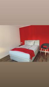 sypialnia z łóżkiem z czerwoną ścianą w obiekcie Stadtvilla Lingen w mieście Lingen