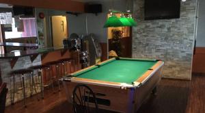 a pool table in a bar with a green at Hotel Motel Hospitalité in Lévis