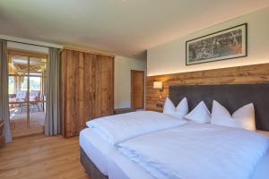 a bedroom with a large white bed with white pillows at Chalet Menkenhof in Reit im Winkl