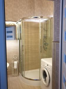 y baño con ducha y lavadora. en Apartament Marina, Villa Marea, en Międzyzdroje