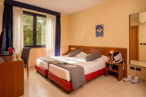 una camera d'albergo con letto, scrivania e finestra di Best Western Blu Hotel Roma a Roma