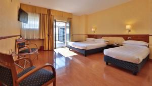 a hotel room with two beds and a television at Best Western Hotel I Colli in Macerata +96 photos