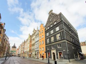 a black building on a city street with buildings at Goma Rent Długa Old Town Gdańsk in Gdańsk