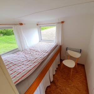 ein kleines Schlafzimmer mit einem Bett und einem Fenster in der Unterkunft Ferienwohnung mit Tiny House in Freienwill