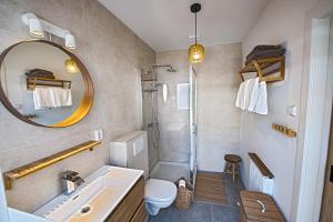 ein Badezimmer mit Waschbecken, Toilette und Spiegel in der Unterkunft Sea Cottage Zandvoort in Zandvoort + 22 Fotos