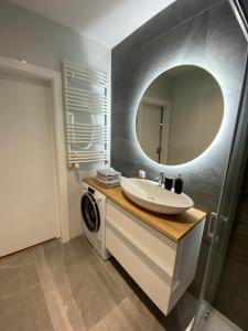 a bathroom with a sink and a washing machine at F&J #25 Centropolis in Toruń