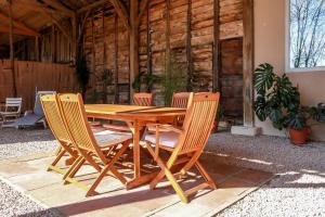 uma mesa de madeira e cadeiras num pátio em Gîte rural Aqui-naut em Montesquieu-Volvestre