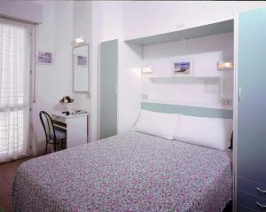 a bedroom with a bed and a desk and a table at HOTEL SILVANA in Cattolica