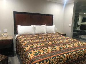 a bedroom with a large bed with a large headboard at Economy Inn - Ontario Airport in Ontario