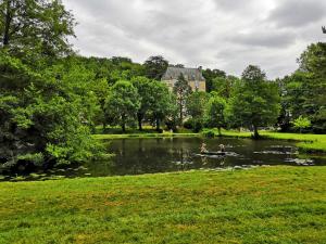 Dos personas están en un bote en un estanque en La Suite Du Marquis, en Saint-Paterne-Racan