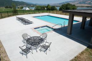 a patio with chairs and a table next to a swimming pool at Huntsville, Utah Townhome near Snowbasin Ski Resort EW 28 in Huntsville