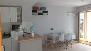 a kitchen with a table and chairs and a white refrigerator at Zlatiborska ćurka in Zlatibor