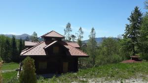a house with a roof on a hill with trees at Zlatiborska ćurka in Zlatibor +18 photos