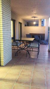 um pátio com uma mesa e cadeiras num piso de azulejo em 2 bedrooms appartement with city view shared pool and enclosed garden at Sant Jordi Castellon em Sant Jordi