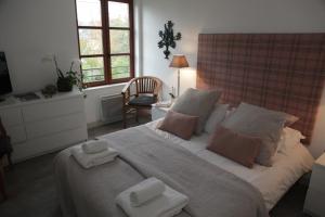 una camera da letto con un grande letto con asciugamani di B&B Le Fond de la Cour a Honfleur