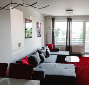 uma sala de estar com um sofá cinzento e um tapete vermelho em AH Radnica em Košice