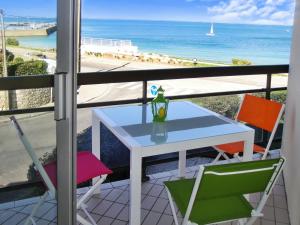 una mesa y sillas en un balcón con vistas al océano en Appartement d'une chambre a Quiberon a 50 m de la plage avec vue sur la mer balcon amenage et wifi en Quiberon