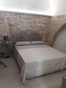 una camera con letto e parete in pietra di B&B A Casett a Fasano