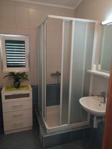 a bathroom with a shower and a sink at Apartmani California in Podgora +36 photos