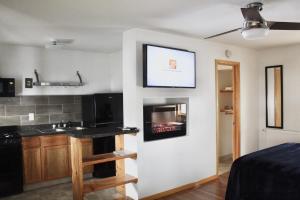 a room with a kitchen with a tv on the wall at Lakes Inn in Detroit Lakes