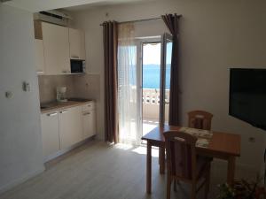 a kitchen and dining room with a view of the ocean at Apartmani California in Podgora