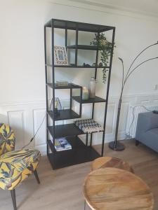 a black book shelf in a living room with a table at Bospark De Schaapskooi in Epe