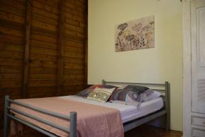 uma pequena cama num quarto com paredes de madeira em Maison créole, côté plage Bel emplacement em Port-Louis
