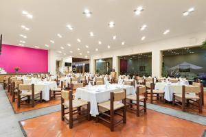 a banquet hall with white tables and chairs at Hotel Rancho San Diego Grand Spa Resort in Ixtapan de la Sal