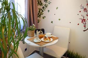 a table with breakfast food on it in a room with a plant at B&B Sorrento Central in Sorrento