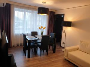ein Wohnzimmer mit einem Tisch, Stühlen und einem Sofa in der Unterkunft MARBEO 5 star luxury suites - Elkonu in Liepāja
