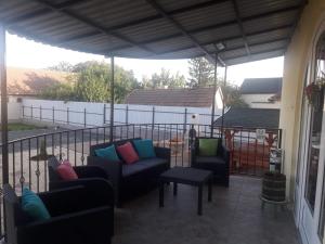 a patio with couches and chairs on a balcony at Tokaj vendégház in Tokaj